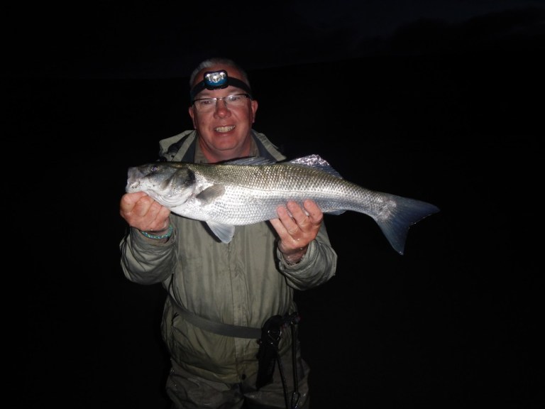 Martin's fishing mate Paul with a dawn caught bass from an Irish surf beach